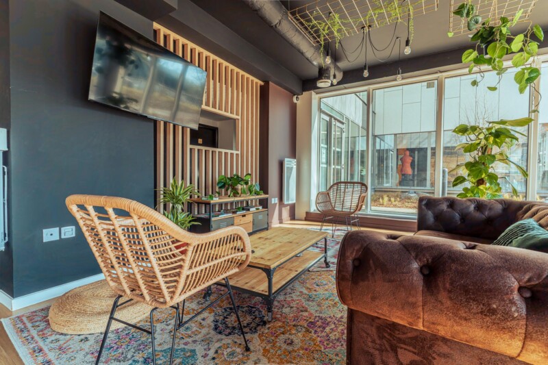 Salle commune de la résidence étudiante Babylone à Lille, avec un canapé, des chaises et une télé