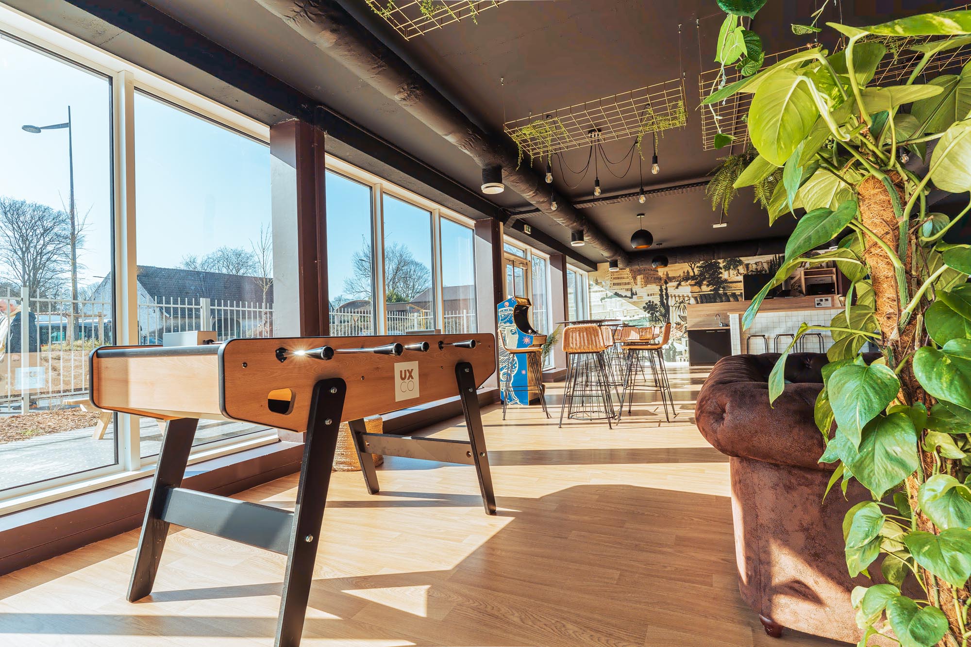 Salle commune de la résidence étudiante Babylone à Lille, avec un canapé, des chaises et un babyfoot