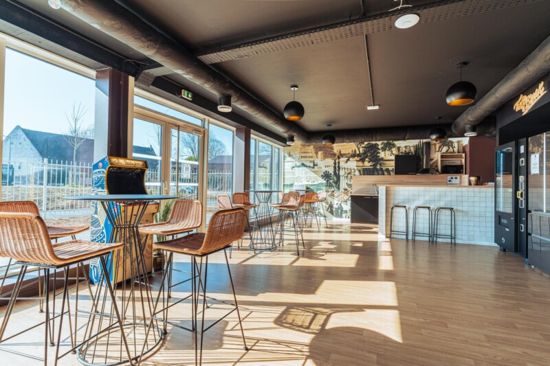 Salle commune de la résidence étudiante Babylone à Lille, avec des chaises et tables et la cuisine partagée
