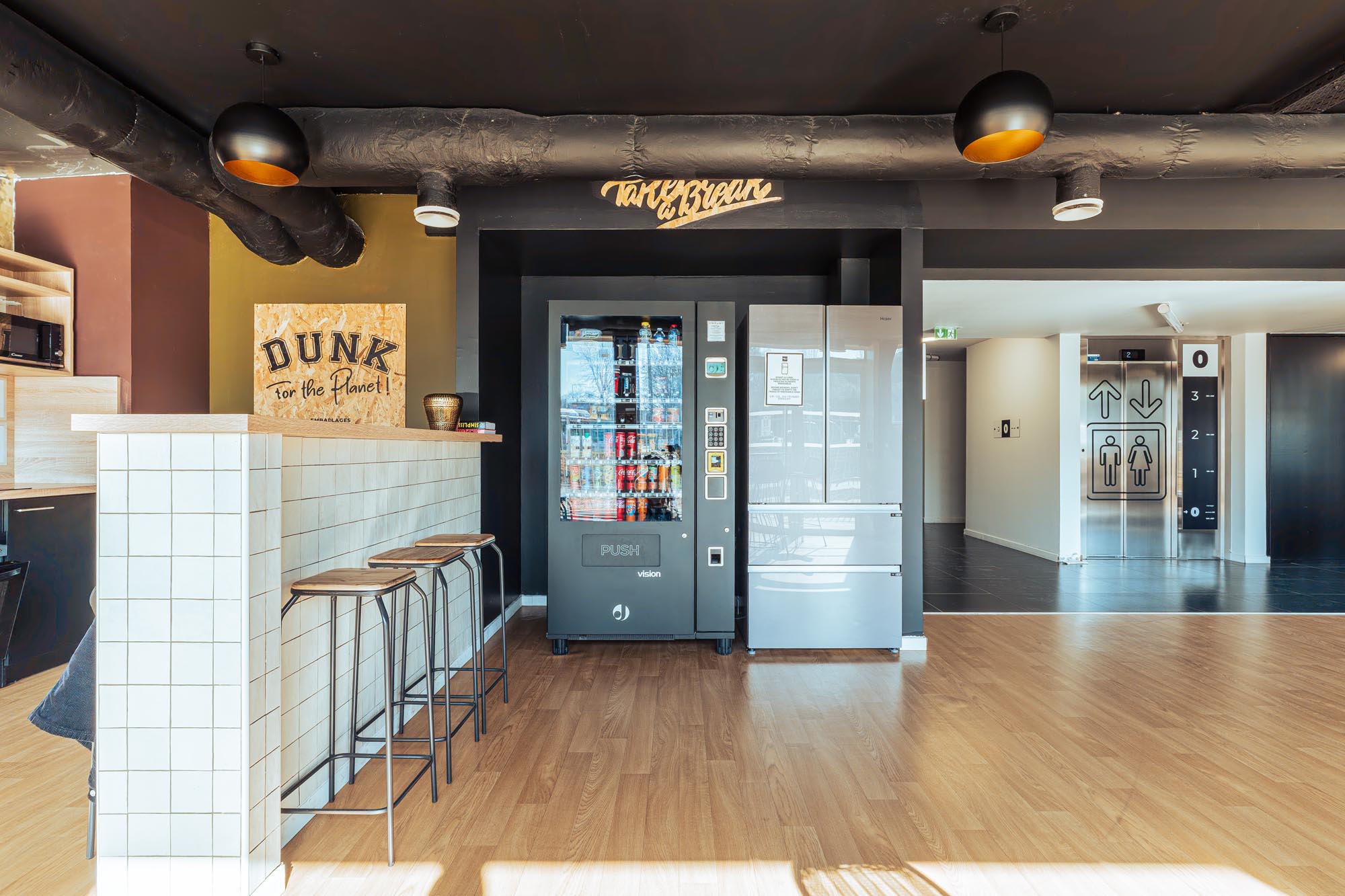 Salle commune de la résidence étudiante Babylone à Lille, avec frigo et distributeur