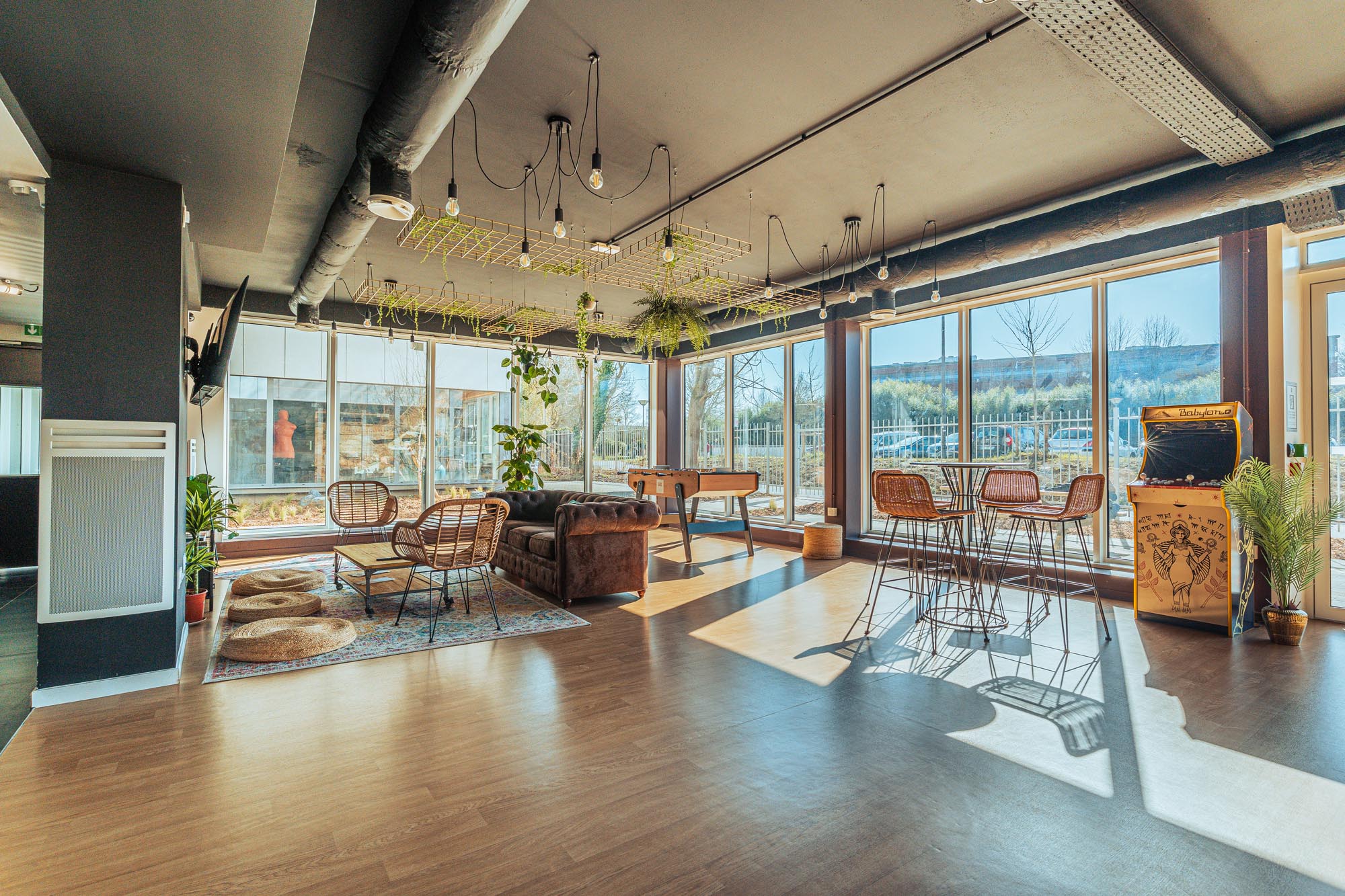 Salle commune de la résidence étudiante Babylone à Lille, avec des chaises et tables et canapé