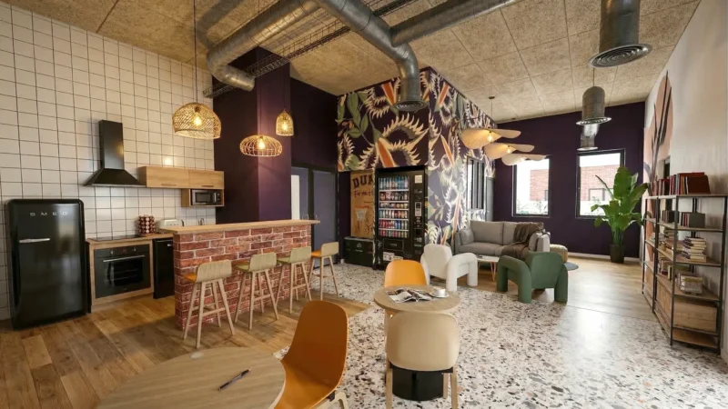 Salle commune en résidence à Saint-Ouen avec cuisine équipée, espace détente et bibliothèque pour les résidents